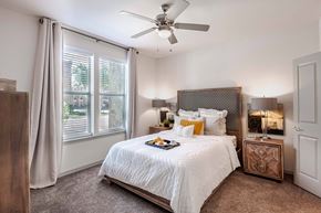 Mckinney apartment for rent - a bedroom with a large bed and a ceiling fan at Discovery at Craig Ranch, McKinney, Texas