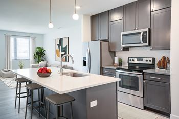 A modern kitchen with a large island and stainless steel appliances.