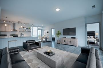 Indianapolis apartment for rent - A modern living room with a black leather couch and a grey coffee table.