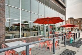 Indianapolis apartment for rent - Table with chairs and Umbrella outside the building at 747 Apartments, Indiana, 46202