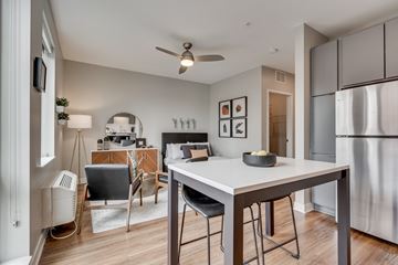 Minneapolis apartment for rent - an open kitchen and living room with a dining table and a refrigerator