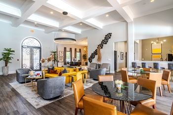 A modern living room with a black table and yellow chairs.