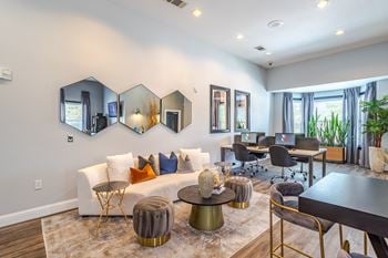 A modern living room with a white couch, a coffee table, and a large mirror on the wall.