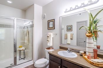 A bathroom with a toilet, sink, and mirror.
