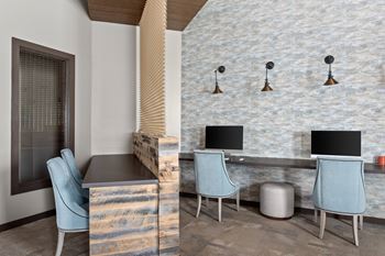 Business center with computer monitors and stone accent wall