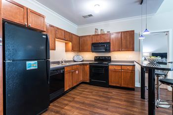 A kitchen with wooden cabinets and black appliances.