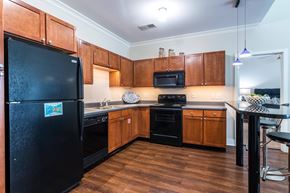 North Kansas City apartment for rent - A kitchen with wooden cabinets and black appliances. at CityView, North Kansas City, Missouri