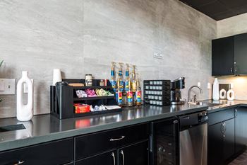 A kitchen with black cabinets and a grey countertop.