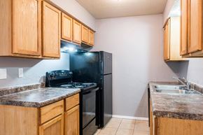 Springfield apartment for rent - A kitchen with wooden cabinets and a black refrigerator.at 3TEN, Springfield
