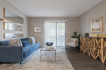 Overland Park apartment for rent - A living room with a blue couch and a wooden coffee table.