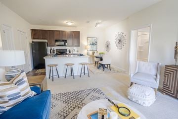 Pickerington apartment for rent - A living room with a blue couch and a white chair.