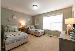 Shawnee apartment for rent - A bedroom with two beds and a nightstand with a lamp.
