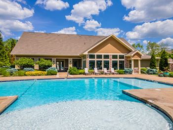 A swimming pool with a house in the background