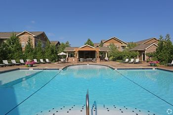 A swimming pool with apartments in the background