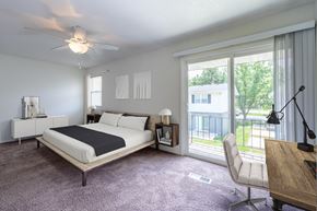 Springfield townhouse for rent - A bedroom with a large bed and a balcony view at Spring Creek Townhomes Apartments, Illinois 62702
