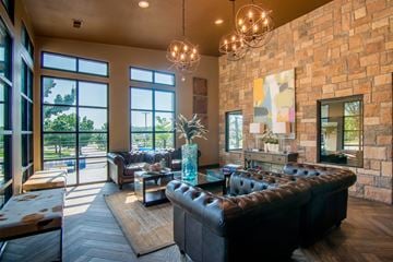 Roeland Park apartment for rent - A living room with a black leather couch and a chandelier.
