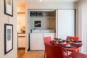 Roeland Park apartment for rent - A kitchen with a table and chairs in the foreground and a washing machine in the background.