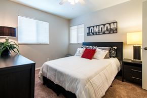 Roeland Park apartment for rent - A bedroom with a white bed and a black headboard with the word "London" written on it.