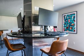 Mission apartment for rent - A modern workspace with a round table, two chairs, and a computer setup.
