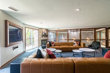 Mission apartment for rent - A living room with a brown leather couch and a television on the wall.