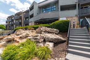 Mission apartment for rent - Exterior stairway with natural rock landscaping and greenery at The Falls Apartments, Mission, Kansas