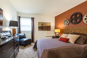 Mission apartment for rent - A bedroom with a bed, dresser, and window.