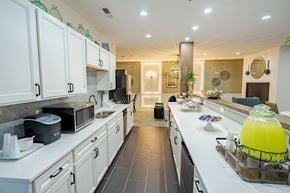 Hilliard apartment for rent - A kitchen with white cabinets and a black refrigerator. at The Greyson, Ohio, 43026