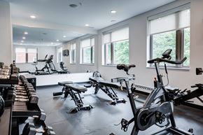 Indianapolis apartment for rent - A gym with a row of treadmills and stationary bikes. at The MK, Indiana, 46220