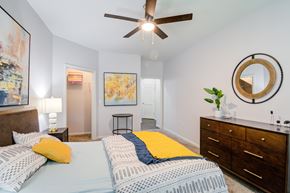 Overland Park apartment for rent - A bedroom with a bed, a ceiling fan, and a painting on the wall at Sovereign at Overland Park Apartments, Overland Park, 66213