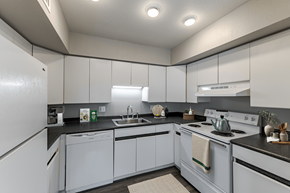 Roeland Park apartment for rent - A kitchen with white cabinets and black countertops.