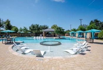 A large swimming pool with chairs around it