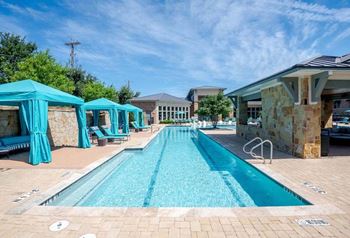 A swimming pool with cabanas and a resort style pool
