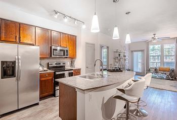 A kitchen with a island and a stainless steel refrigerator