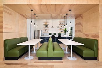 A living room with green couches and a white table