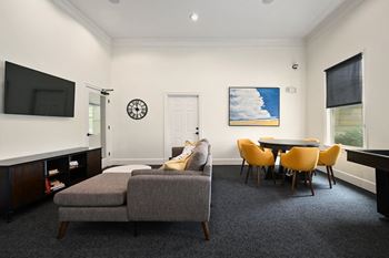 A living room with a couch and a table and chairs