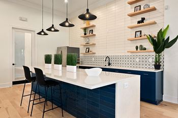 A kitchen with a large white counter top and blue cabinets