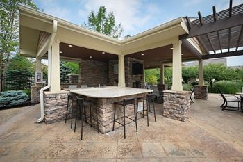 A covered patio with an outdoor kitchen and bar
