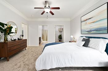 A bedroom with a large bed and a ceiling fan