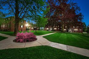 Lancaster apartment for rent - a sidewalk in front of a brick building at night