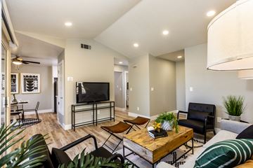 Modesto apartment for rent - A living room with a wooden coffee table and a black couch.