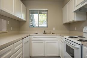 Eugene apartment for rent - Two Bedroom w/ Den | Kitchen with white cabinets and white appliances.