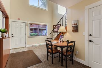 Oak Grove apartment for rent - A dining room with a brown rug and a wooden table with chairs.
