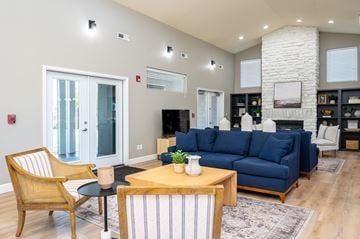 Kennewick apartment for rent - A living room with a blue couch and a wooden chair.