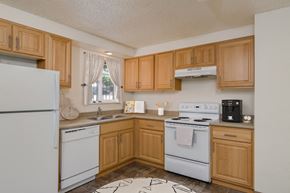 Corvallis apartment for rent - a kitchen with white appliances and wooden cabinets