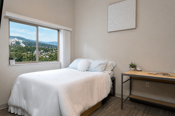 Eugene apartment for rent - A bedroom with a large bed and a view of the city.