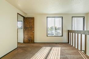 Albany apartment for rent - A room with a brown carpet and a wooden door.