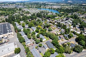 Eugene apartment for rent - A bird's eye view of a residential area with houses, trees, and a parking lot.