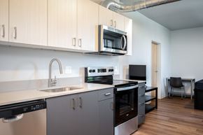 Eugene apartment for rent - a kitchen with white cabinets and a sink and a microwave