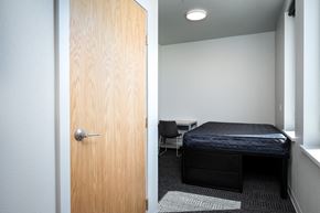 Eugene apartment for rent - a bedroom with a bed and a door to a room with a desk