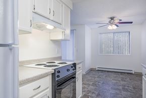 Salem apartment for rent - a kitchen with white cabinets and a stove and a ceiling fan